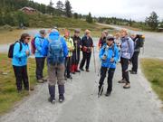 Bildet viser gruppen stående på en grusvei og får orientering om hvordan de nå skal gå videre.