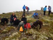 Bildet viser noen av turdeltagerene som har pause nære en liten topp.