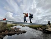 Skranglete og vippende bru uten rekkverk: Knut og Ulf bruker kjeppen langs kanten.